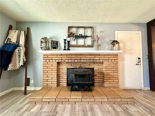 room details with a textured ceiling, a wood stove, and wood-type flooring