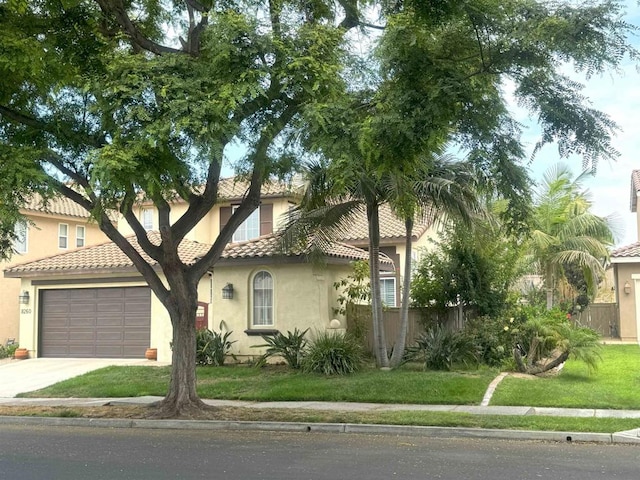 mediterranean / spanish-style home featuring a garage and a front yard