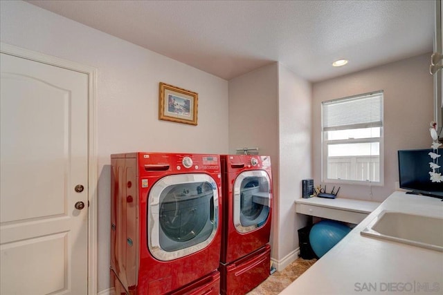 laundry room with a textured ceiling, sink, and washer and dryer