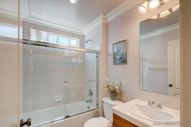 full bathroom featuring a textured ceiling, shower / bath combination with glass door, crown molding, vanity, and toilet