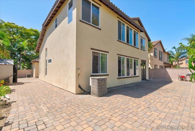 back of property with a patio and central AC unit