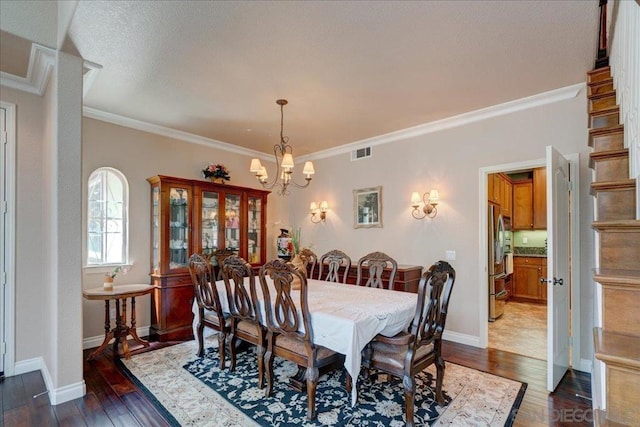 dining area featuring an inviting chandelier, crown molding, and dark wood-type flooring