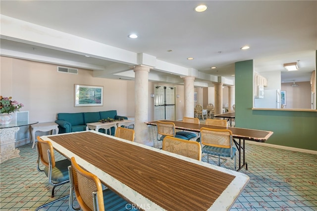 carpeted dining area featuring ornate columns