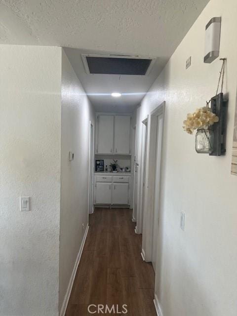 corridor with dark wood-type flooring and a textured ceiling