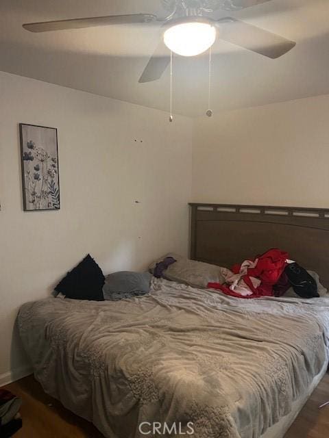 bedroom with dark hardwood / wood-style flooring and ceiling fan