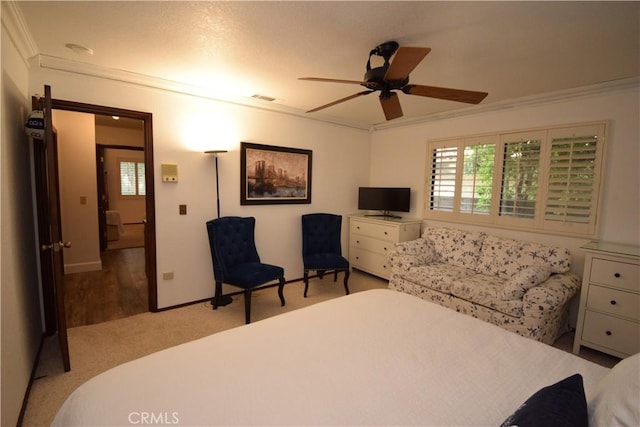 carpeted bedroom featuring crown molding and ceiling fan