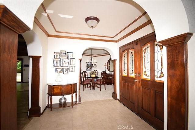 entrance foyer with crown molding and a chandelier