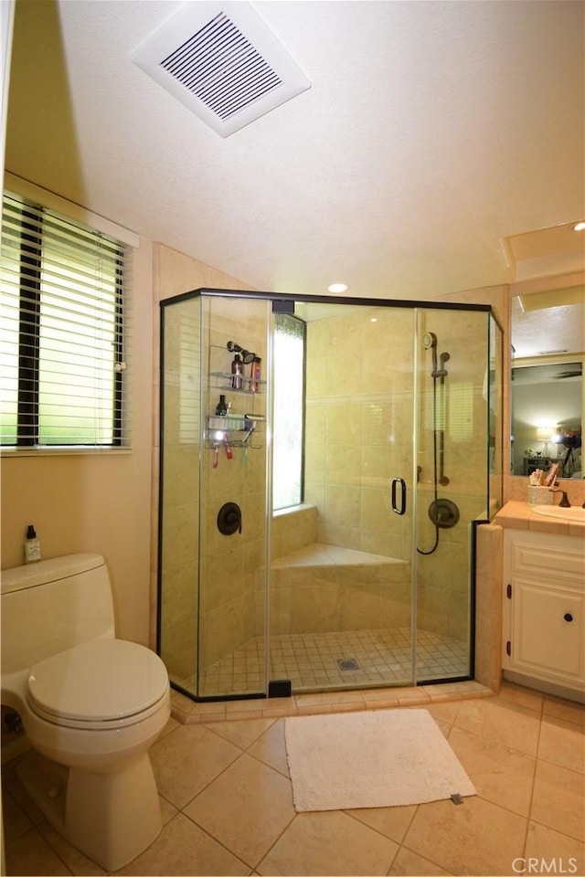 bathroom featuring toilet, vanity, tile patterned floors, and walk in shower