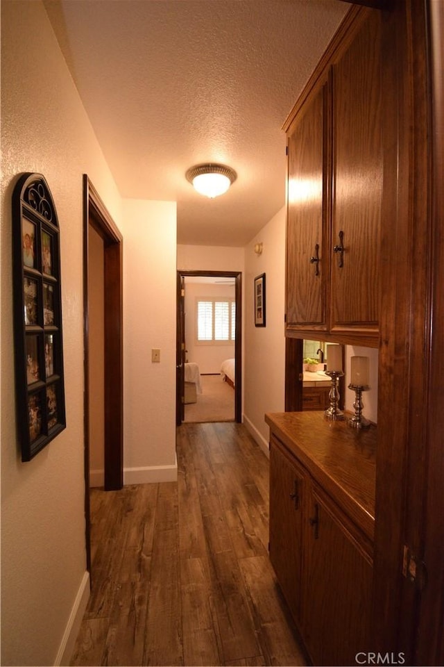 hallway featuring a textured ceiling and dark wood-type flooring