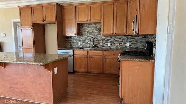 kitchen with dark wood-type flooring, sink, a kitchen breakfast bar, stainless steel appliances, and backsplash