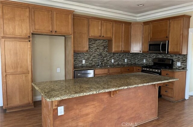 26759 Columbia St, Hemet, CA 92544 - kitchen featuring stainless steel appliances, wood finished floors, dark stone counters, decorative backsplash, and crown molding