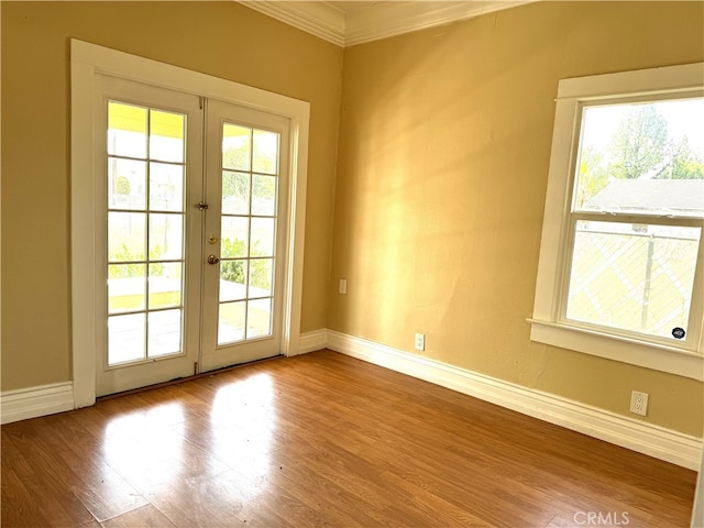 doorway to outside featuring french doors, light hardwood / wood-style flooring, ornamental molding, and a healthy amount of sunlight