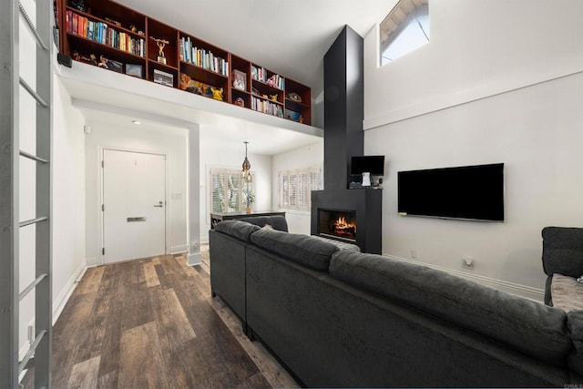 living room with a towering ceiling and wood-type flooring