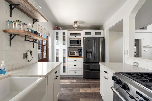 kitchen featuring tasteful backsplash, stainless steel appliances, and white cabinets