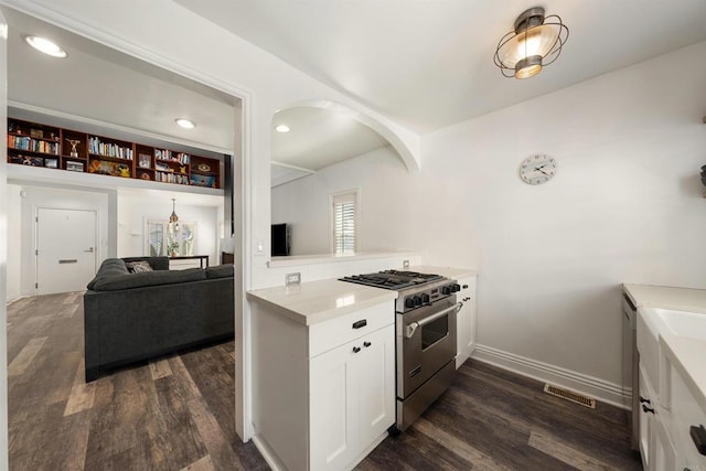 kitchen with dark wood-type flooring, high end range, and white cabinets