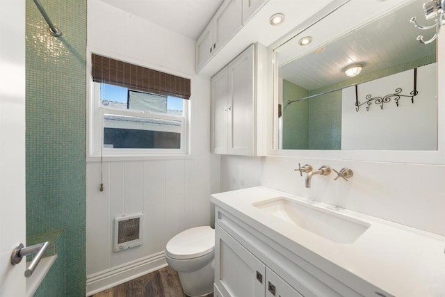 bathroom with toilet, heating unit, a shower, vanity, and hardwood / wood-style floors