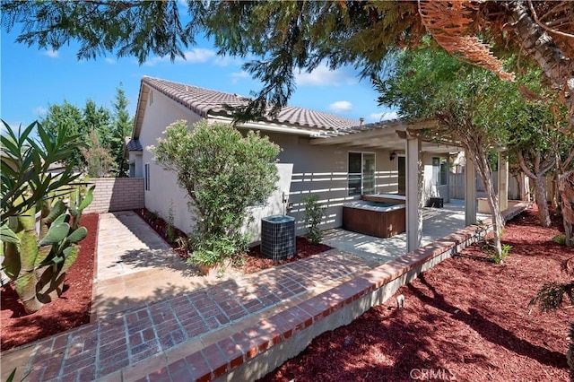 view of front of house with central AC, a patio, and a hot tub