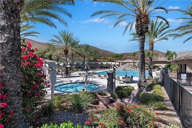 view of swimming pool featuring a mountain view and a hot tub