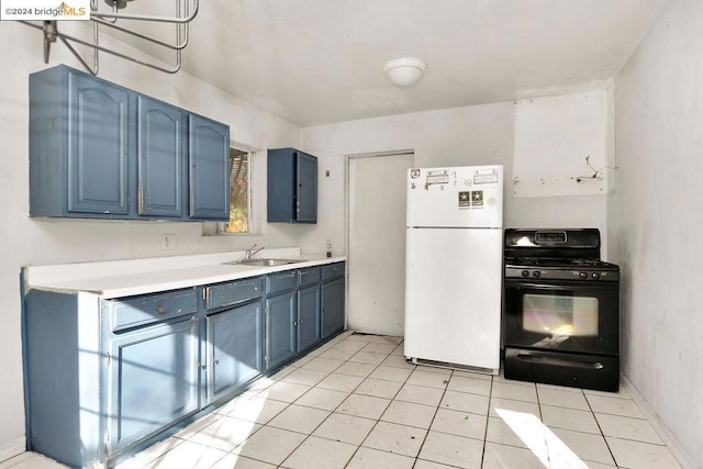 kitchen featuring black gas range, blue cabinetry, white fridge, and sink