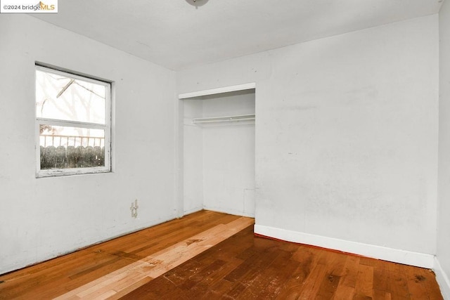 unfurnished bedroom featuring dark hardwood / wood-style floors and a closet