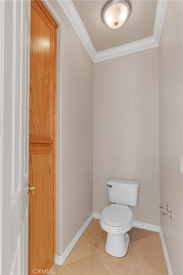 bathroom featuring tile patterned floors, crown molding, and toilet