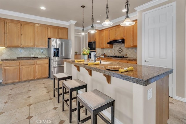 kitchen with black appliances, decorative light fixtures, a kitchen island with sink, and tasteful backsplash