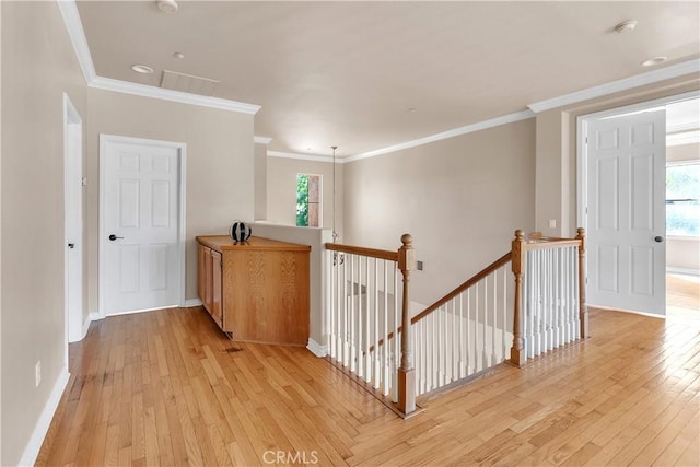 hallway featuring crown molding and light hardwood / wood-style flooring