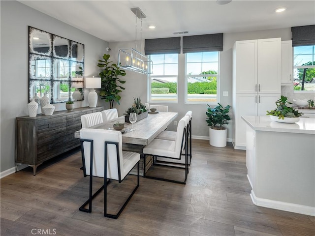 dining space featuring dark hardwood / wood-style floors, a wealth of natural light, and a notable chandelier