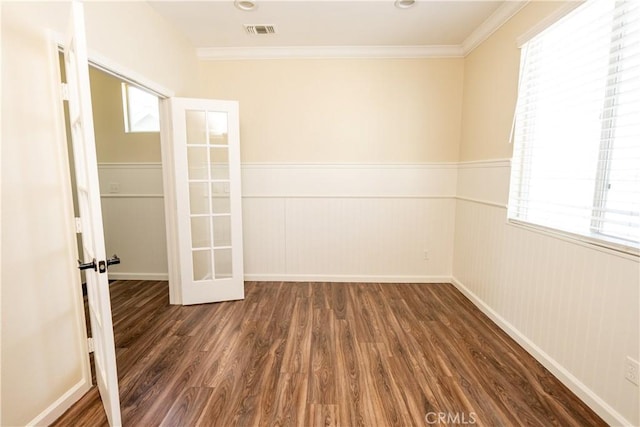 empty room featuring dark hardwood / wood-style floors, ornamental molding, and french doors