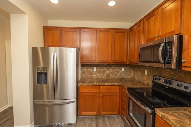 kitchen with dark hardwood / wood-style floors, stainless steel appliances, and tasteful backsplash