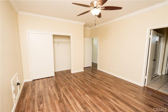 unfurnished bedroom featuring hardwood / wood-style floors, ceiling fan, crown molding, and a closet