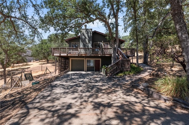 back of property featuring a wooden deck and a garage