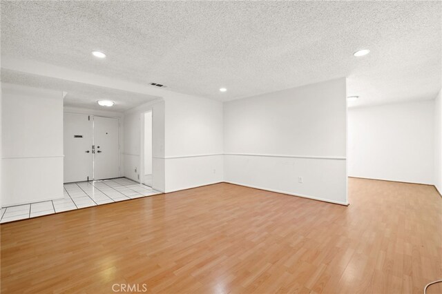 empty room featuring light hardwood / wood-style floors and a textured ceiling