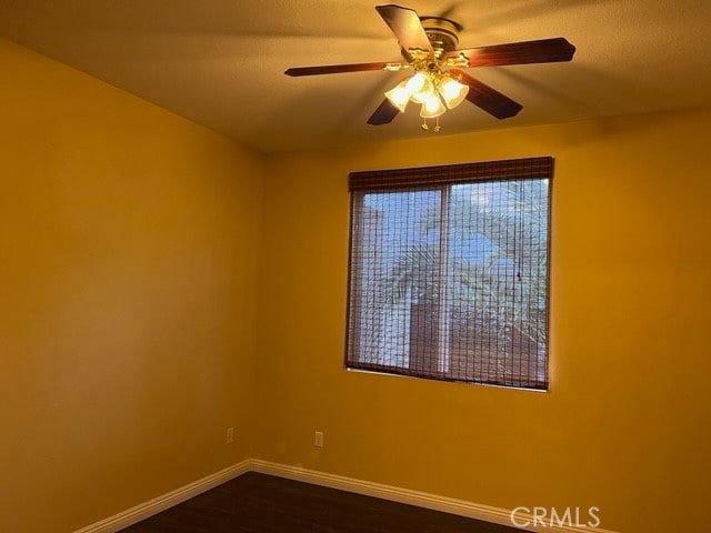 spare room featuring dark hardwood / wood-style floors and ceiling fan