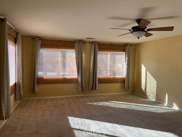 empty room with ceiling fan and carpet flooring