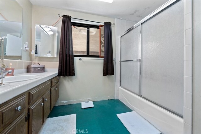 bathroom with vanity and combined bath / shower with glass door