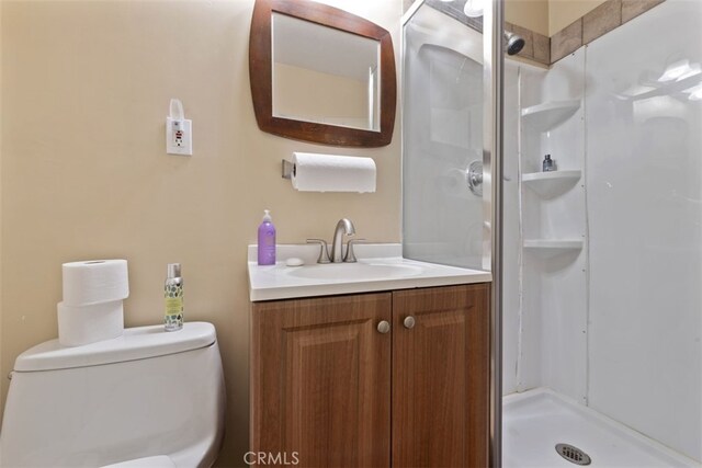 bathroom featuring a shower, vanity, and toilet