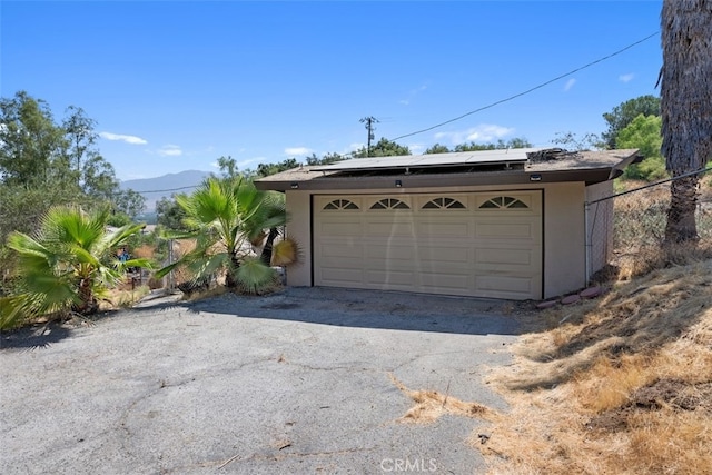 garage featuring solar panels and a mountain view