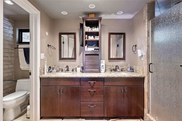 bathroom with a shower with door, vanity, and toilet