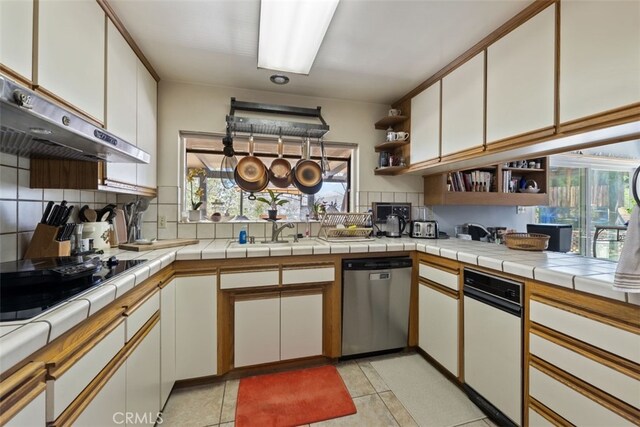 kitchen with dishwasher, light tile patterned flooring, tasteful backsplash, white cabinets, and tile countertops