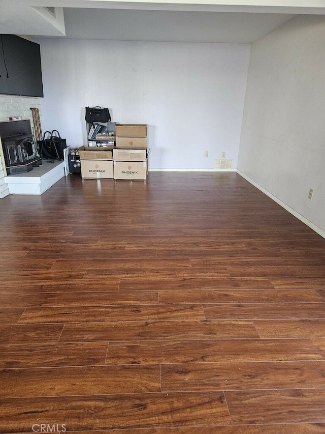 interior space with dark hardwood / wood-style floors and a wood stove