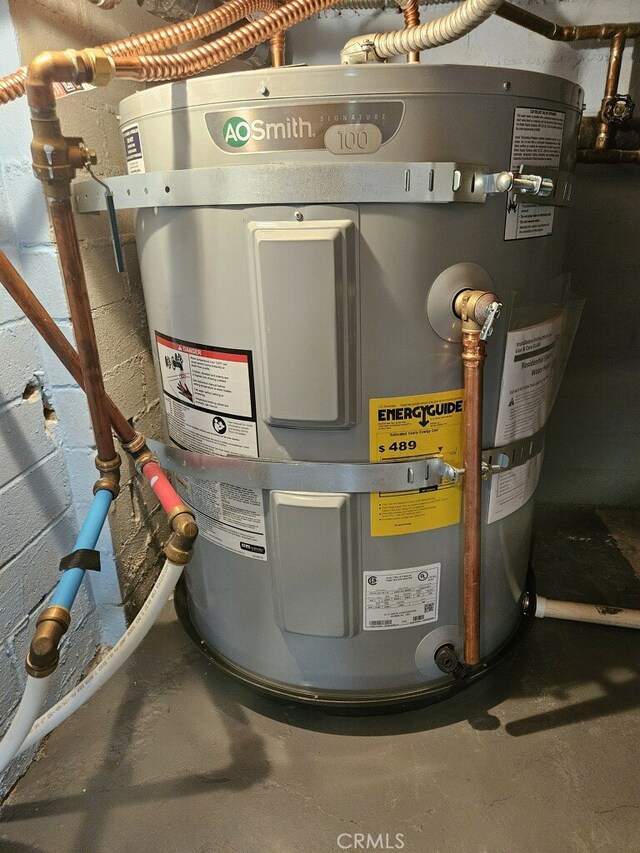 utility room featuring strapped water heater