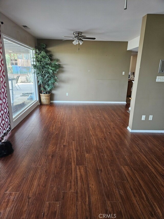 unfurnished room with ceiling fan and dark wood-type flooring