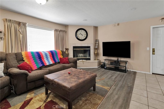 living room featuring a tiled fireplace and tile patterned flooring