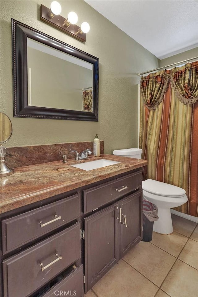 bathroom featuring vanity, tile patterned flooring, and toilet