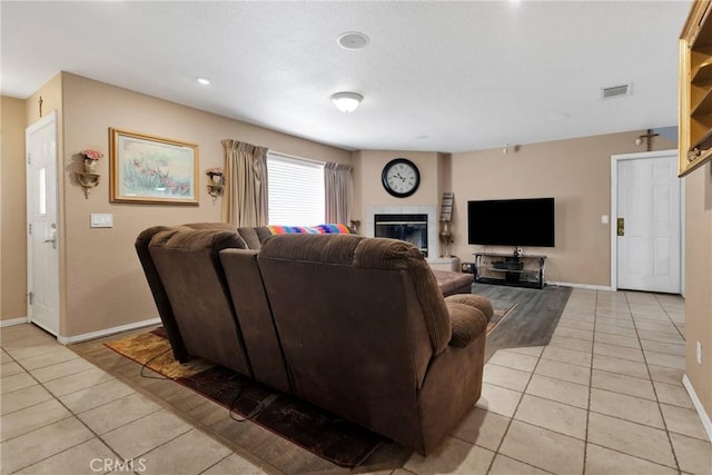 tiled living room featuring a tiled fireplace