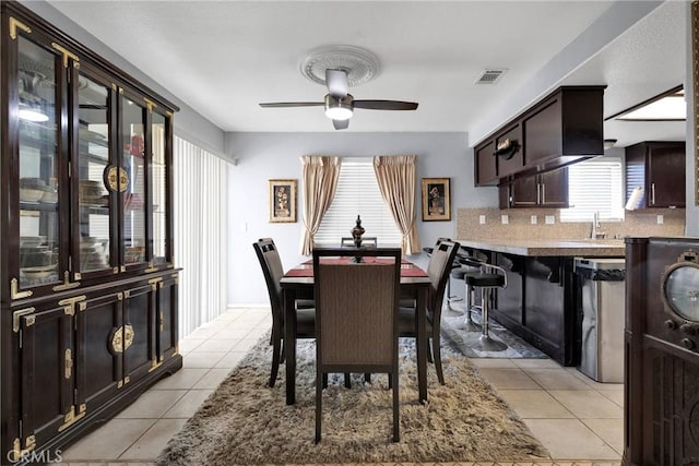 tiled dining room featuring ceiling fan and sink