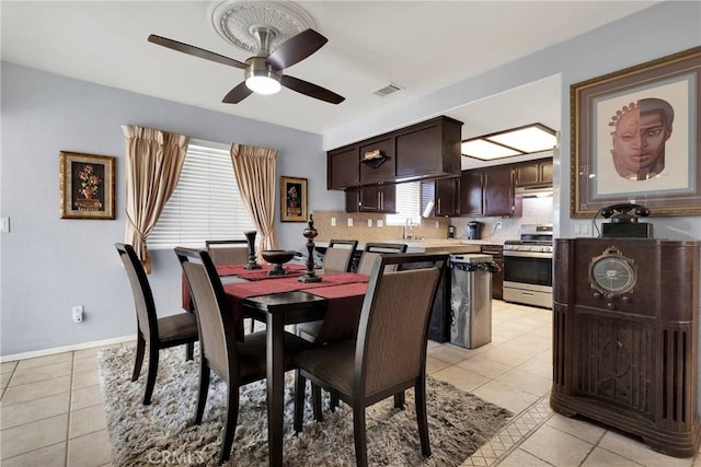 tiled dining space with sink and ceiling fan