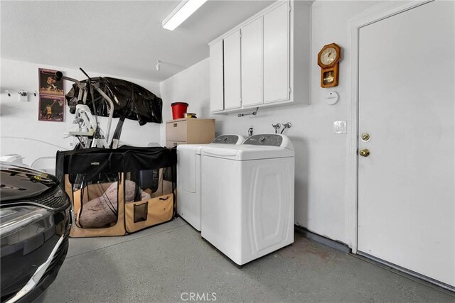 washroom featuring cabinets and washing machine and clothes dryer