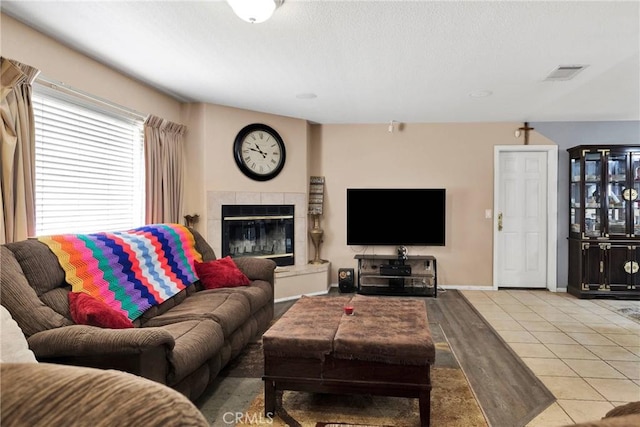 living room featuring a tile fireplace and light hardwood / wood-style flooring